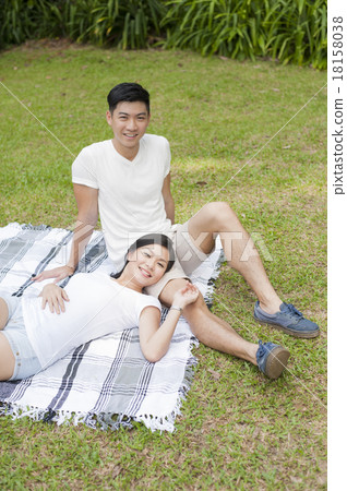 A young couple enjoying some calmness in a park. 18158038