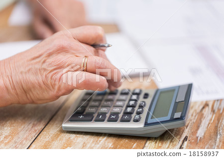 close up of senior woman counting with calculator close up of senior woman counting with calculator 18158937