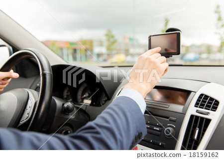 close up of man with gps navigator driving car close up of man with gps navigator driving car 18159162