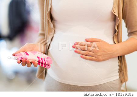 pregnant woman with baby socks at clothing store 18159192
