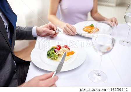close up of couple eating appetizers at restaurant 18159342