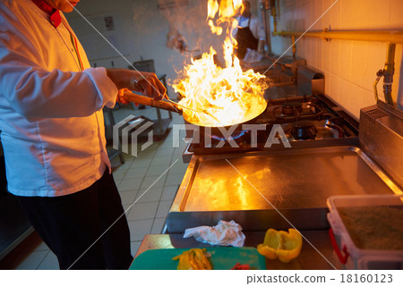 chef in hotel kitchen prepare food with fire chef in hotel kitchen prepare food with fire 18160123