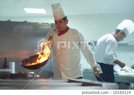 chef in hotel kitchen prepare food with fire chef in hotel kitchen prepare food with fire 18160124