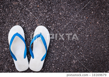 White plastic flip flop shoe on black asphalt road White plastic flip flop shoe on black asphalt road 18169679