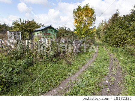 the thrown wooden house and dirt road in rural are 18172325