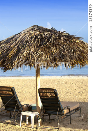 Umbrella and chaise lounges on a beach 18174579