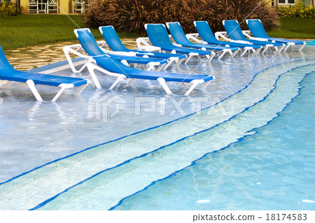 Empty beach chairs near pool Empty beach chairs near pool 18174583