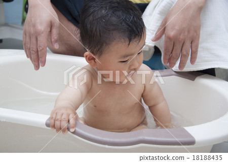 Chinese father washing baby in bathtub Chinese father washing baby in bathtub 18188435