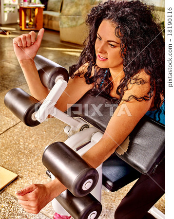 Girl workout on bicep curl machine in sport gym.  18190116