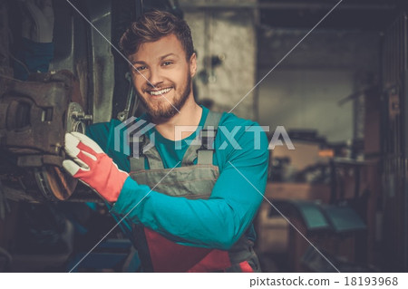 Mechanic checking car brake system in a workshop Mechanic checking car brake system in a workshop 18193968