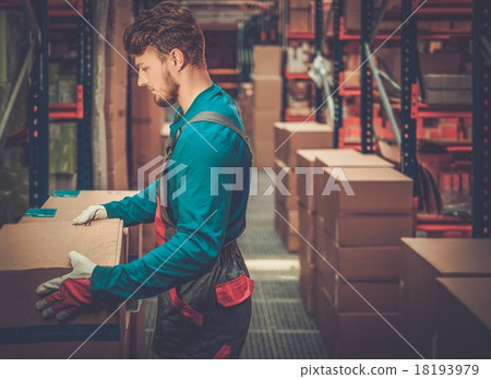 Porter carrying boxes in a warehouse 18193979
