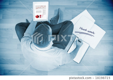 Hard work against young creative businessman looking at tablet 18198723