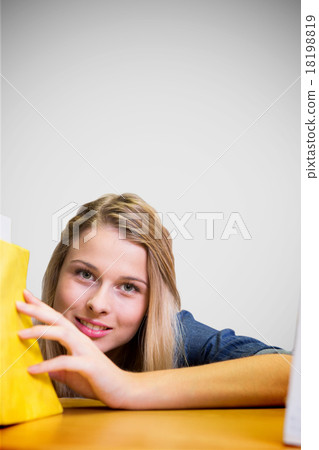 Composite image of pretty student in the library 18198819