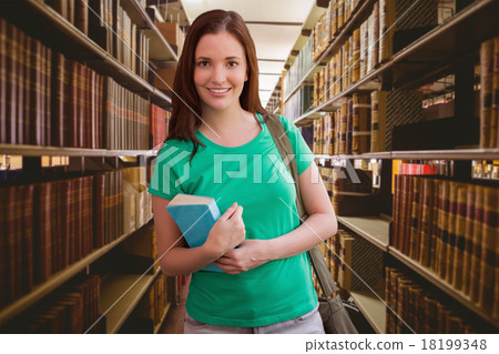 Composite image of student smiling at camera in library Composite image of student smiling at camera in library 18199348