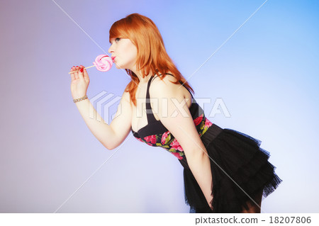 Redhair girl holding sweet food lollipop on blue. 18207806