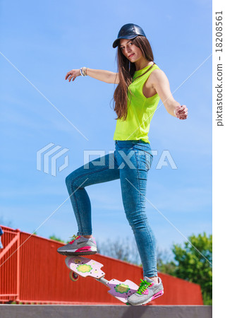 Teen girl skater riding skateboard on street. 18208561