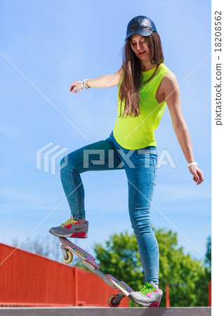 Teen girl skater riding skateboard on street. 18208562