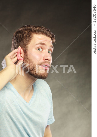 Gossip man eavesdropping with hand to ear. 18208640
