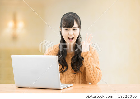 Long hair teenage woman sitting in a simple room wearing a sweater 18220010