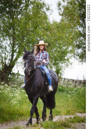 Beautiful young girl riding a horse in countryside 18222821