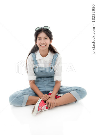 Asian teenage girl smiling and sitting on white  18222980