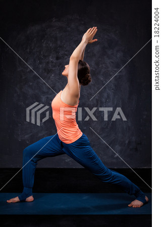 Woman practices yoga asana utthita Virabhadras 18224004
