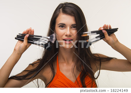 Glamour lady  is showing cosmetic brushes. 18224149