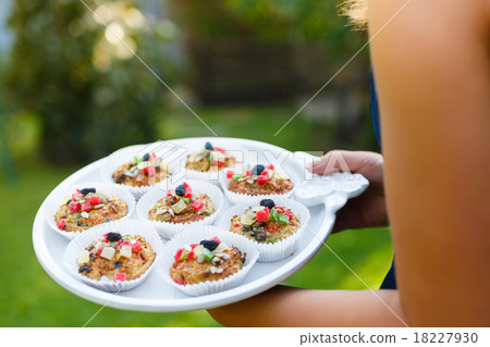 Young woman holding a tray with cupcakes Young woman holding a tray with cupcakes 18227930
