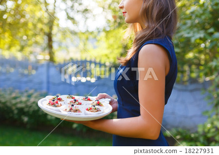 Young woman holding a tray with cupcakes Young woman holding a tray with cupcakes 18227931