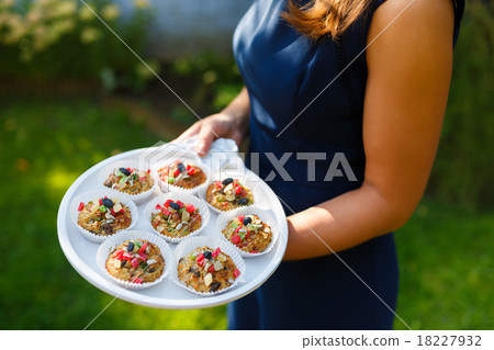 Young woman holding a tray with cupcakes Young woman holding a tray with cupcakes 18227932