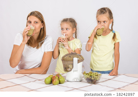 Mother and two daughters taste the freshly prepare Mother and two daughters taste the freshly prepare 18242897