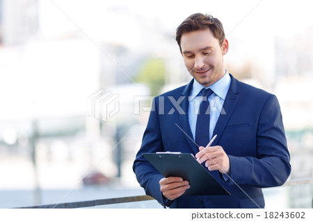 Gentleman in suit using a clipboard. 18243602