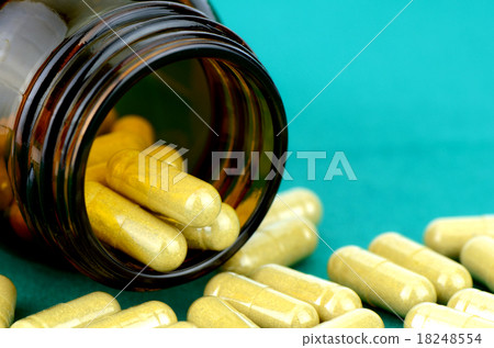 Dried herb capsule on green cloth background. 18248554