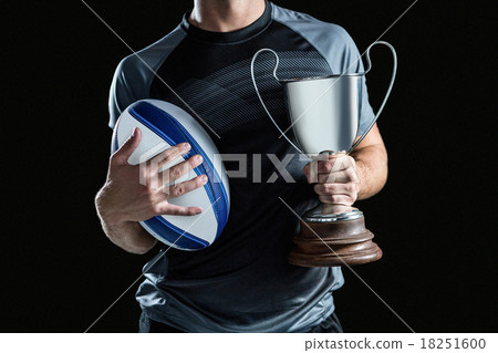 Midsection of successful rugby player holding trophy and ball Midsection of successful rugby player holding trophy and ball 18251600