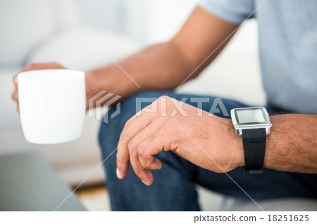 Close-up of man on coffee break with smart watch Close-up of man on coffee break with smart watch 18251625