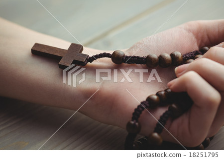 Woman holding wooden rosary beads Woman holding wooden rosary beads 18251795
