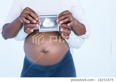 Mid section of couple holding ultrasound scan 18251874