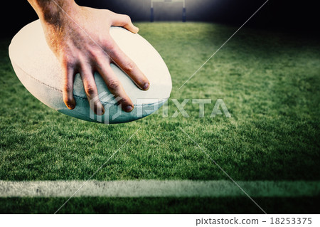 Composite image of rugby player posing feet on the ball Composite image of rugby player posing feet on the ball 18253375
