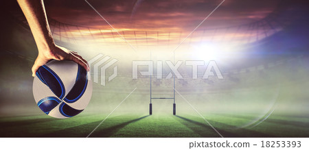 Composite image of rugby player with arm raised holding ball 18253393
