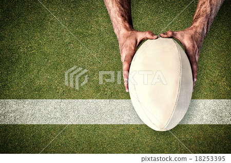 Composite image of man holding rugby ball Composite image of man holding rugby ball 18253395