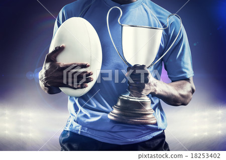 Composite image of mid section of sportsman holding trophy and r Composite image of mid section of sportsman holding trophy and r 18253402