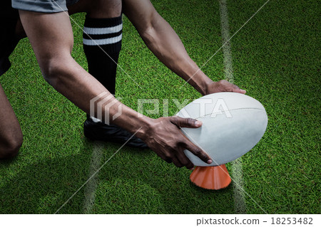 Composite image of cropped image of sportsman keeping rugby ball on kicking tee 18253482