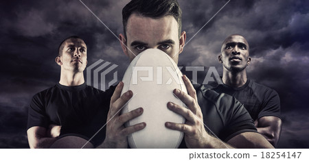 Composite image of tough rugby player holding ball 18254147