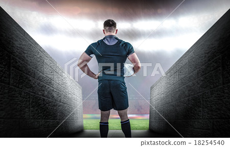 Composite image of rugby player holding the ball 18254540