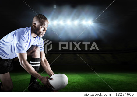 Composite image of rugby player looking away while keeping ball 18254600