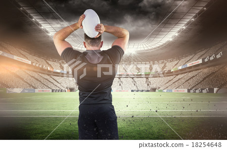 Composite image of tough rugby player throwing ball 18254648