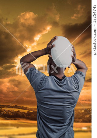 Composite image of rear view of sportsman throwing rugby ball 18254745