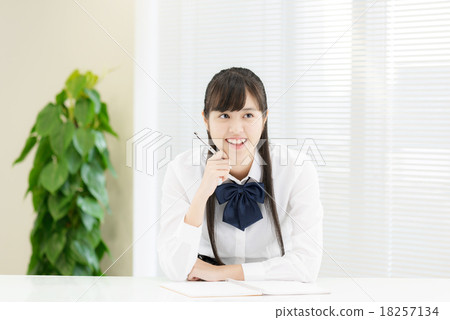 制服的學校女孩在一張白色桌前面 18257134
