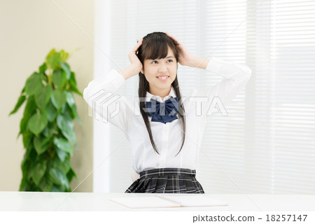 制服的學校女孩在一張白色桌前面 18257147