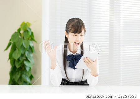 School girls in uniform in front of a white table School girls in uniform in front of a white table 18257558